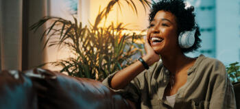 Woman listening to a podcast Black woman with headphones on